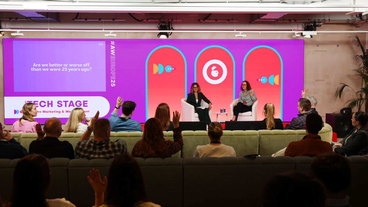 Presenters on stage at Ad week. The audience has their hands raised