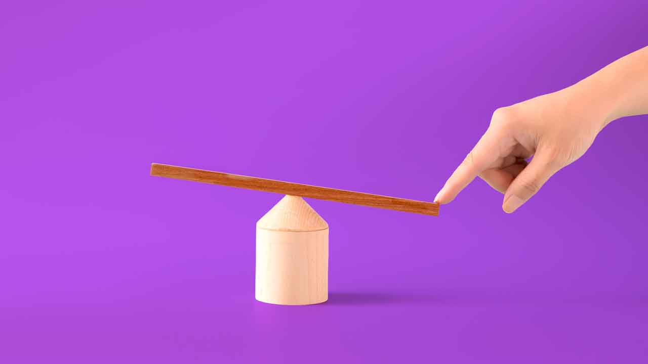A minimalist composition with a light-wood plank balanced on a cylindrical block on a magenta backdrop. A finger is pressing down on one side, illustrating the artificial weighting or skewing of a sample to favor specific data insights.