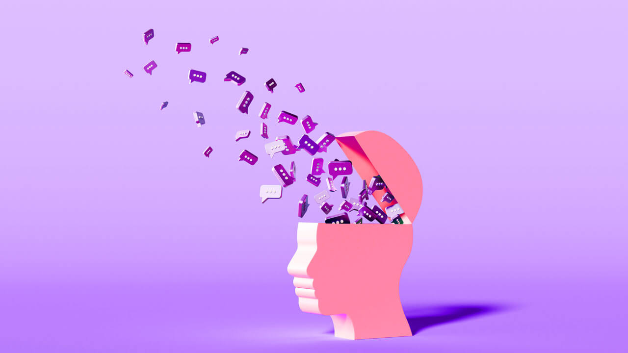 A 3D minimal graphic on a light purple background featuring a pink profile bust of a human head with an open top, out of which a stream of purple speech bubble icons floats upward, symbolizing AI-moderated interviews, conversational qualitative insights, and hybrid market research methodologies.